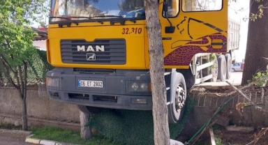 Yoldan çıkan kamyon duvarda asılı kaldı