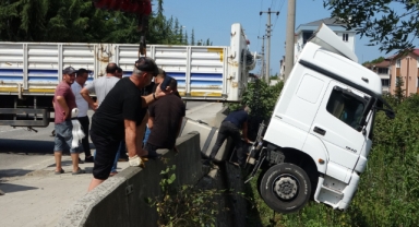 Freni boşalan tır yola sürüklendi, istinat duvarında asılı kaldı