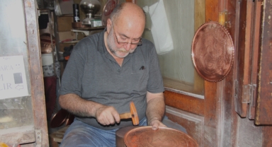 Türkü söyleyerek bakıra şekil veriyor   