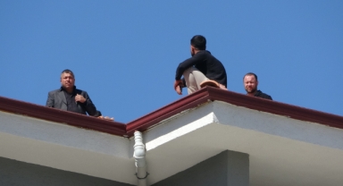 Alacağını alamadı çatıya çıktı, polis yiyecek verip indirdi