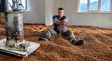 Hasat ettiği fındığını soba ateşinin ısısıyla kurutmaya çalışıyor